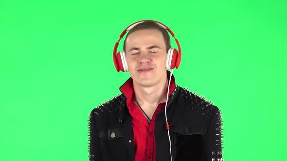 Guy Dancing and Enjoys Music in Big Red Headphones. Green Screen