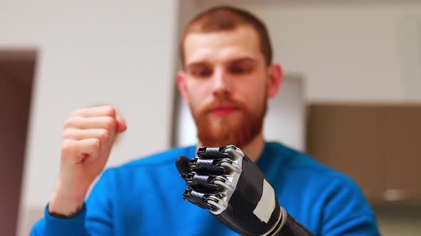 Young Man with Modern Biotechnology Hand in Apartment