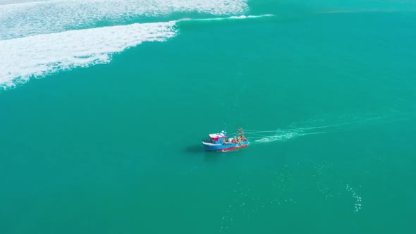 Fishing Boat Floating on Ocean Waves Near Shore