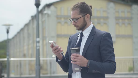 Side View of Serious Confident Businessman Surfing Internet on Smartphone Outdoors. Portrait of