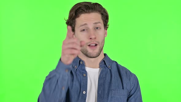 Cheerful Young Man Pointing at the Camera on Green Chroma Key
