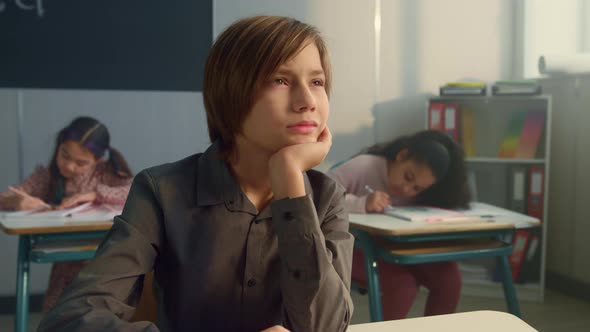 Boy Studying in Classroom with Classmates