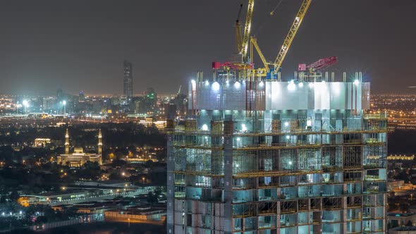 Construction Activity in Dubai Downtown with Cranes and Workers Night Timelapse UAE