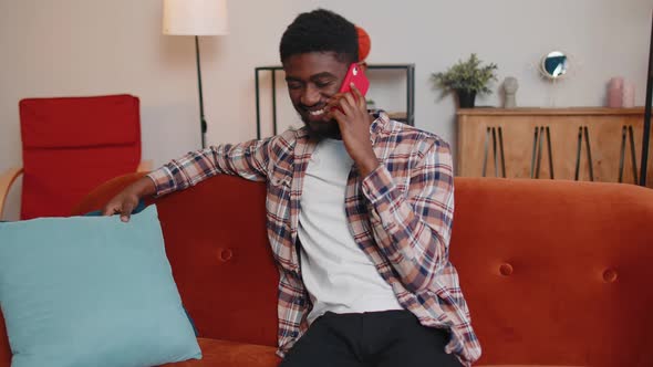 Young Adult African American Man Enjoying Talking Mobile Phone Conversation with Friends at Home