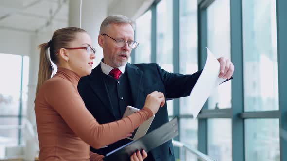 Senior businessman discussing presentation with woman assistance
