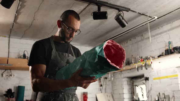 A male creator, sculptor, handyman creates a handmade art object.