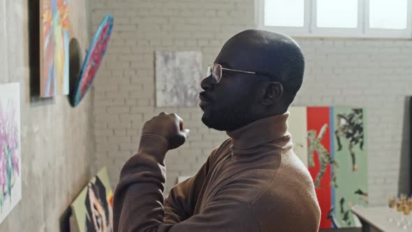 Black Man Looking at Paintings