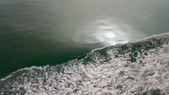 Closeup of the Surface of a Wave in Slow Motion From a Boat to a Yacht While Sailing