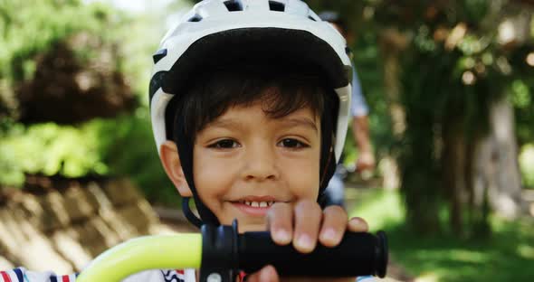 Portrait of smiling boy wearing bicycle helmet in park