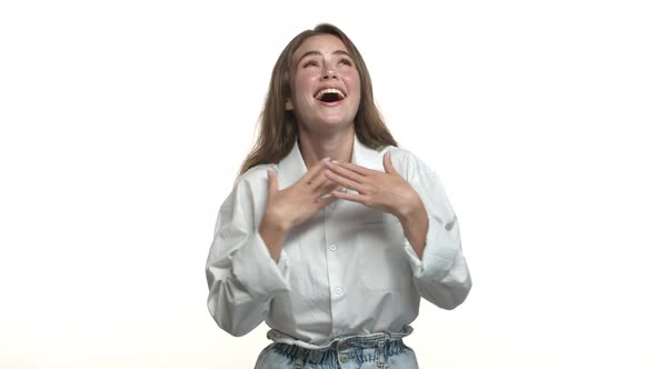 Happy Attractive Female Model in White Shirt Starting to Laugh From Something Funny Standing Over