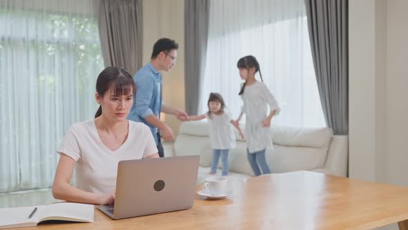 Asian business mother loss concentration on job in computer feel frustrated from family make noise