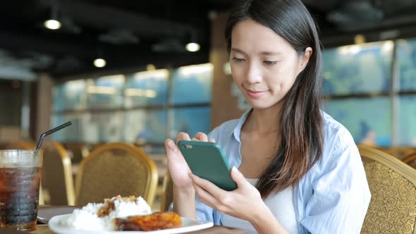 Woman looking at the mobile phone in restaurant