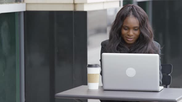 Young businesswoman using laptop computer at outdoor cafe