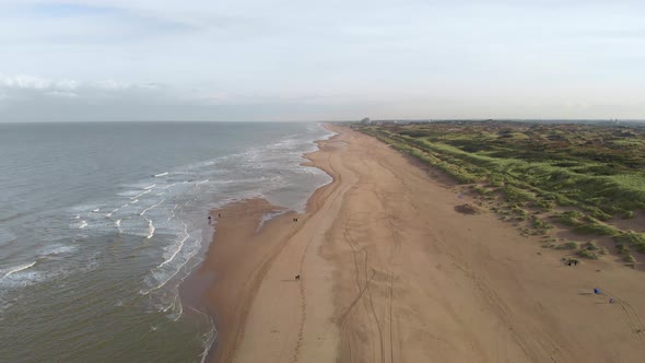 Tourist Walking On Sand Dune At The Shoreline Of North Sea Beach In South Holland, Netherlands. Aeri