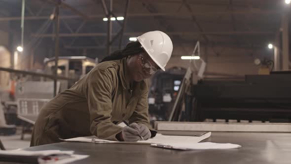 African Architect Making Changes to Blueprint