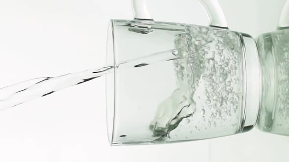 Vertical Video Crystal Clear Water Pouring Into Glass Mug