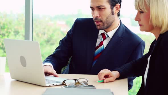 Two Business People Talk Project Strategy at Office