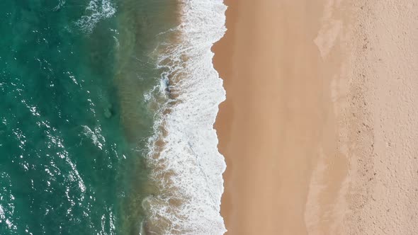 beautiful top view of waves crashing on empty beach sand. Tropical shoreline, paradise