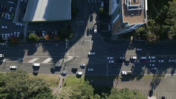 Cars passing the busy highway and T intersection. Aerial horizontal top down view on a sunny day.