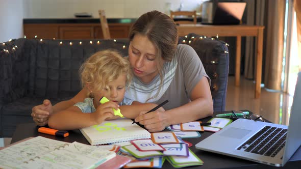 A Teacher, a Tutor for Home Schooling. a Teacher or Mom at the Table with a Little Girl