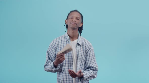 Black Man with a Slight Smile Flips Through a Pack of Dollar Bills with Hand and Slams Banknotes on