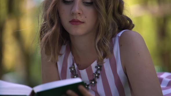 Fashionable Lady with Loose Curly Hair Reads Blurred Book