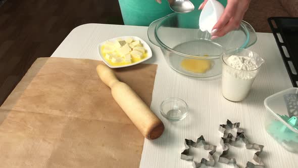 A Woman Mixes The Ingredients For Making A Biscuit In A Container.