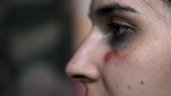 Close-up of a tear on the face of a young woman with a trauma from violence