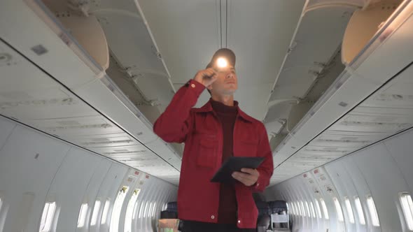 Repair of Passenger Aircraft Cabin. Mechanic Conducts Inspection of the Aircraft