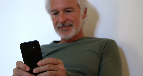 Senior man using mobile phone in bedroom 4k