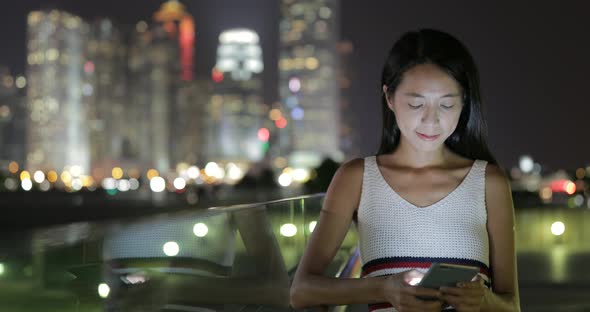 Woman working on cellphone at night 