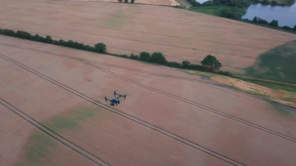 Aerial Landscape View of the Top a Black Drone Flying on the Field