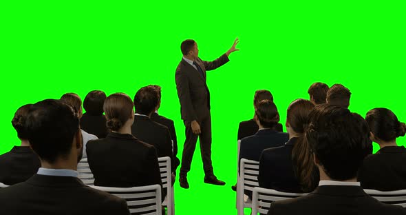 Businessman using futuristic digital screen while giving presentation to colleagues