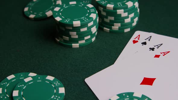 Rotating shot of poker cards and poker chips on a green felt surface - POKER 005