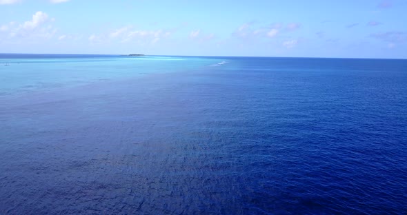 Natural birds eye island view of a white paradise beach and blue ocean background in vibrant 4K