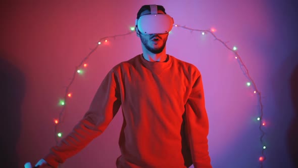 Young Man Playing Videogames with VR Goggles During Christmas Holidays