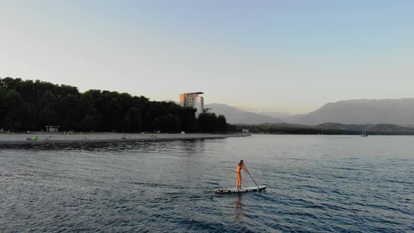 Woman is Floating on SUP Board