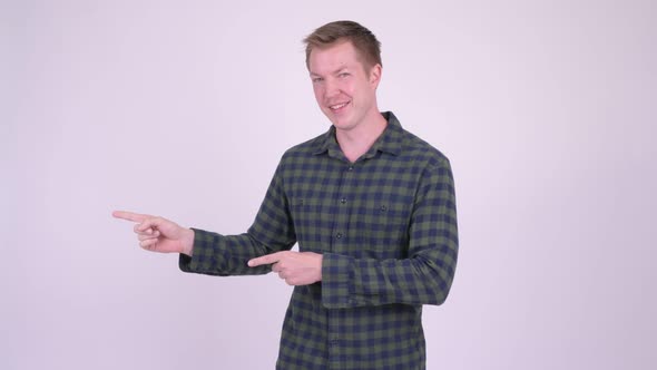 Young Man Showing Copy Space and Pointing Finger Against White Background