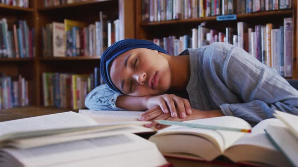 Girl in hijab sleeping in the library