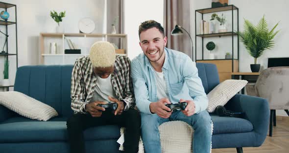 Smiling Gay Couple which Spending Joint Leisure at Gaming at Home