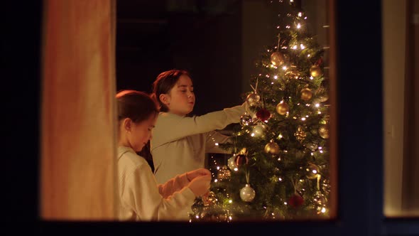 Happy Girls Decorating Christmas Tree at Home