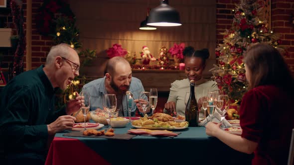 Happy Multiethnic Family Gathered Around Christmas Dinner Table Enjoying Traditional Food