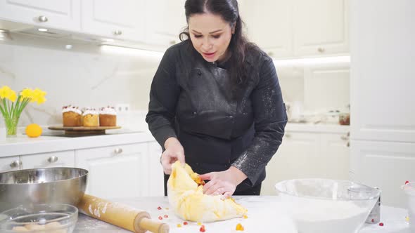 Women Kneads Dough with Candied Fruits for Easter Cakes