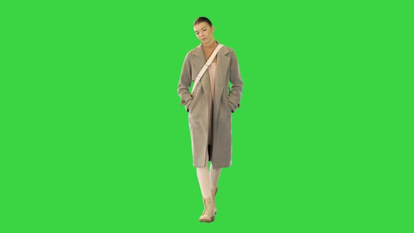 Young Woman in Smart Casual Clothes Walks Slowly on a Green Screen Chroma Key