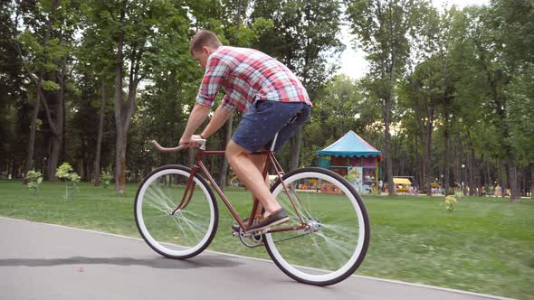 Sporty Guy Cycling at the Park Road