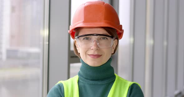 Portrait of a working woman in a construction helmet. The face of a happy female engineer.