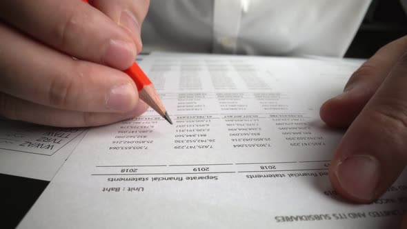 Accountant Analyzing Business Marketing Data on Paper Dashboard at Office Table