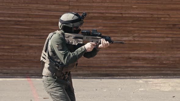 Slow motion of soldier shooting automatic rifle in a range alt