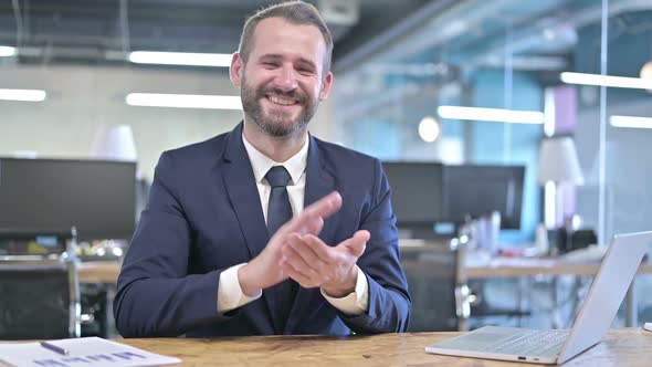 Cheerful Young Businessman Clapping with Hands in Office