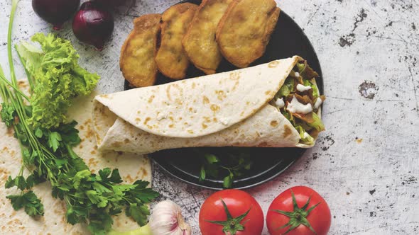 Traditional Turkish Doner Kebab in a Wrap Served with Fresh Ingredients and Deep Fried Dumplings